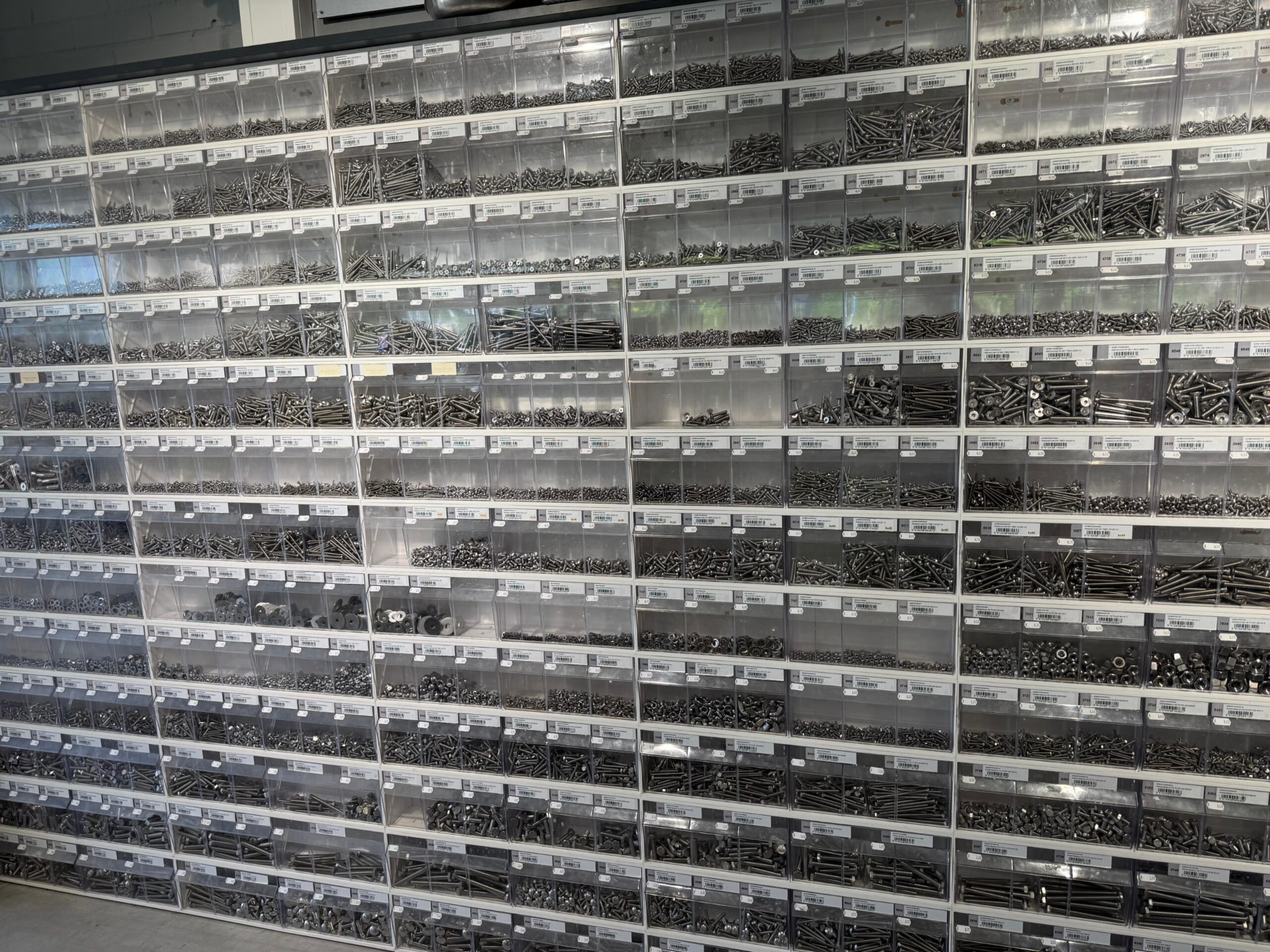 Muur met schroevenbakken in de winkel van Schreurs Wessem BV in Wessem